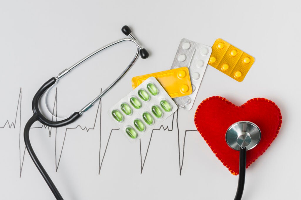 Stethoscope resting on heart with pills on top, symbolizing healthcare and medication.