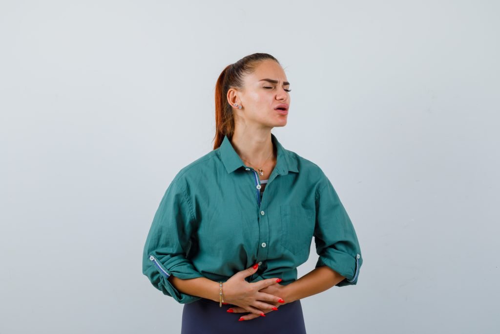 Woman-experiencing-stomach-pain-seeking-help-from-best-orthopedic-doctor-in-Kota-set-against-white-background.jpg