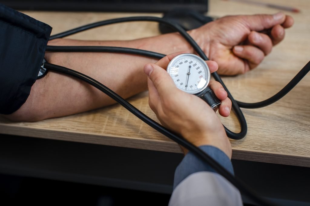 A healthcare professional demonstrating the use of a blood pressure meter for patient assessment.jpg